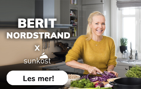 Lege Berit Nordstrand smiler på kjøkkenet mens hun lager mat - i samarbeid med Sunkost